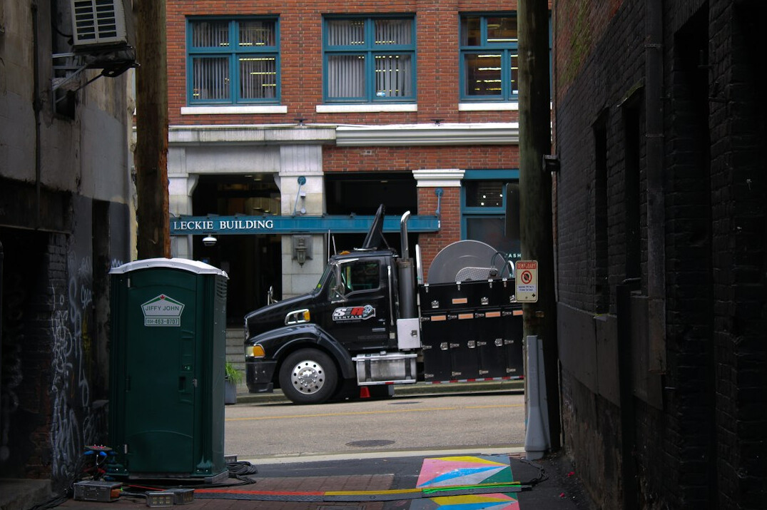 Outside broadcast truck parked on a city street with cables running out